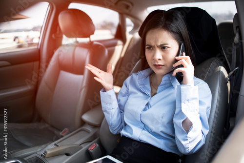 Work stress,Exhausted, Tired,Asian woman talk by mobile calling on cellular phone while sitting in her car, driving under the influence,driver is safely talking by smartphone in a car concept