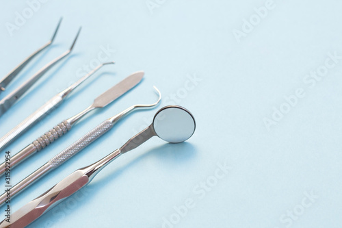Set of Dentist's medical equipment tools. Stainless steel dental equipment on blue background with copy space.