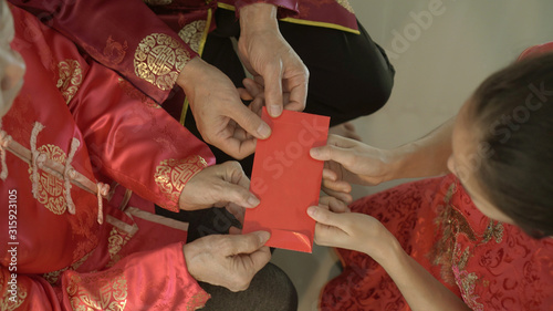 Giving red envelop for Chinese New Year Top view grandparent and five money to child