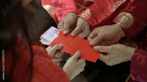 Giving red envelop for Chinese New Year Top view grandparent and five money to child