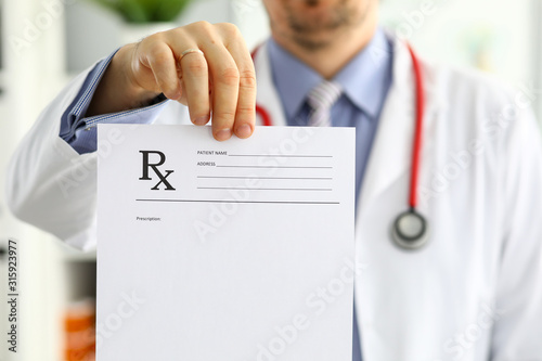 Male medicine doctor hand hold and give prescription form to patient photo