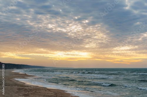 Sunset over the sea. Reflection of sunlight in the sea waves. The sky in the sunset rays.