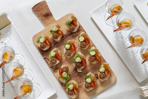 Catering  snacks on the table. Mini Sandwiches with pate and tomatoes  decorated with salad.