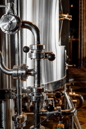 Large reservoirs  tanks and pipes with manometers in private microbrewery. Craft beer production line. Industrial interior background.  View from above.