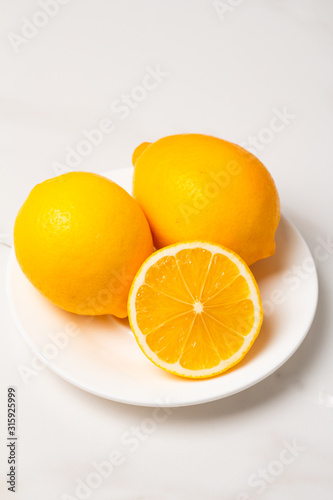 fresh lemons on a white plate close-up