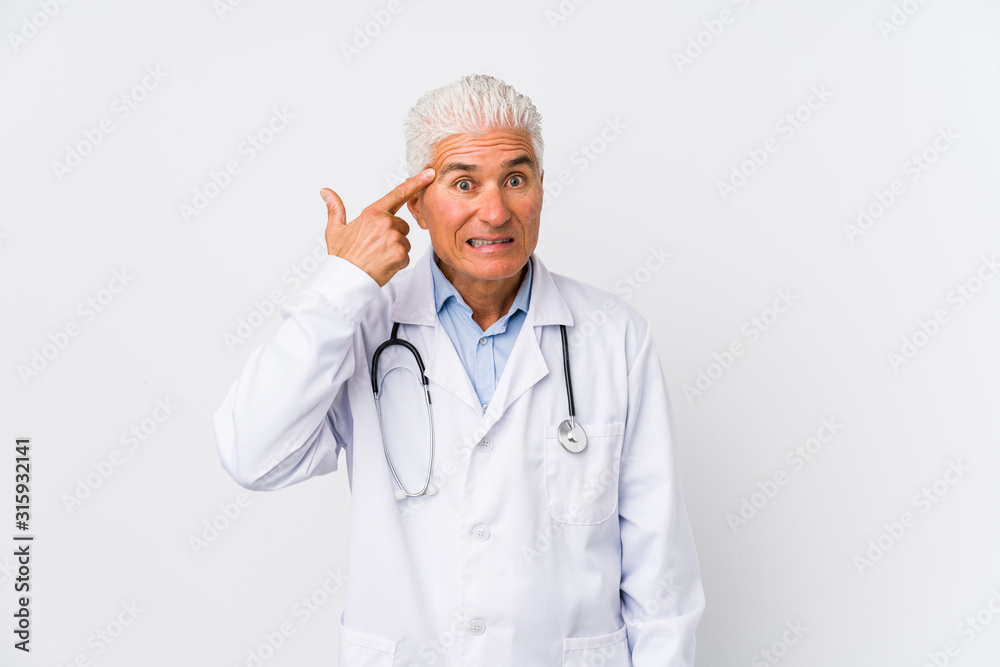 Mature caucasian doctor man showing a disappointment gesture with forefinger. Mature caucasian doctor man showing a disappointment gesture with forefinger.