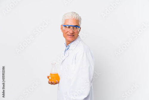 Mature chemical man isolated looks aside smiling, cheerful and pleasant.