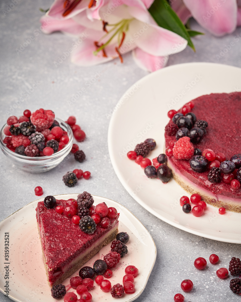 Raw vegan berry cherry cheesecake gluten-free on grey background. Raw vegan berry cherry cheesecake gluten-free on grey background.