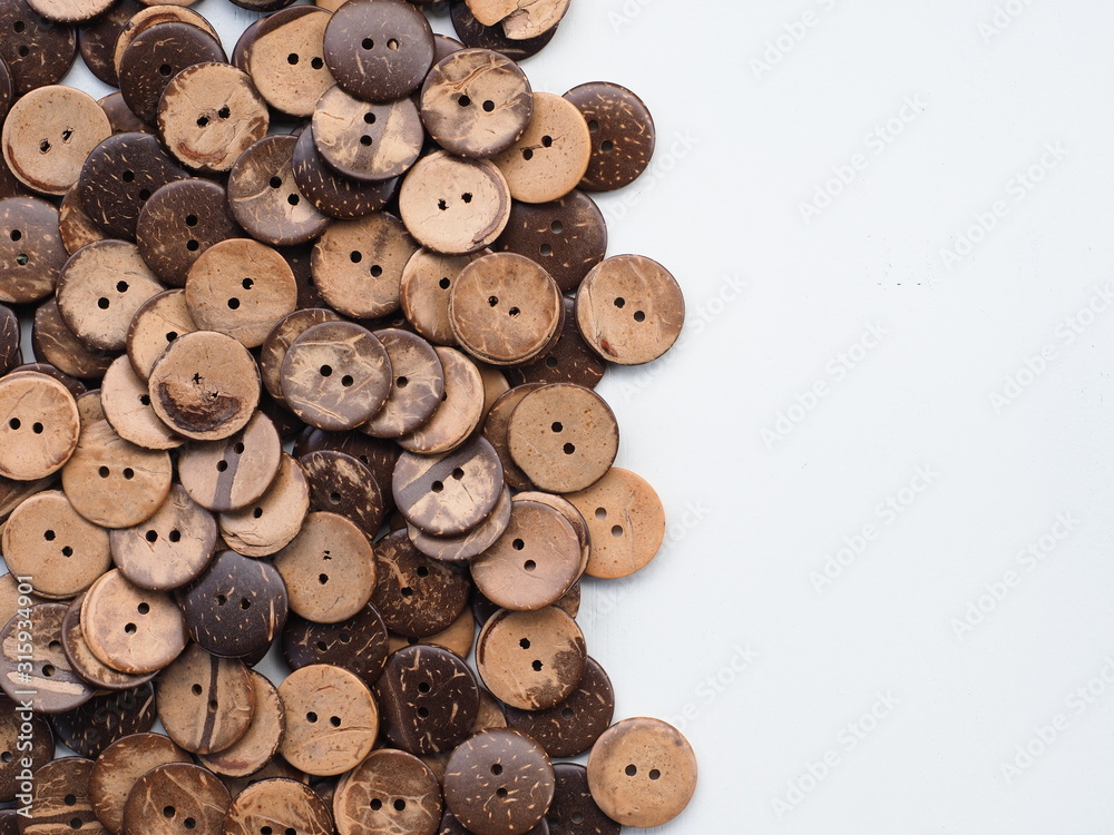Wooden button on a wooden background, Buttons made from Coconut shell, Top view with copy space.
