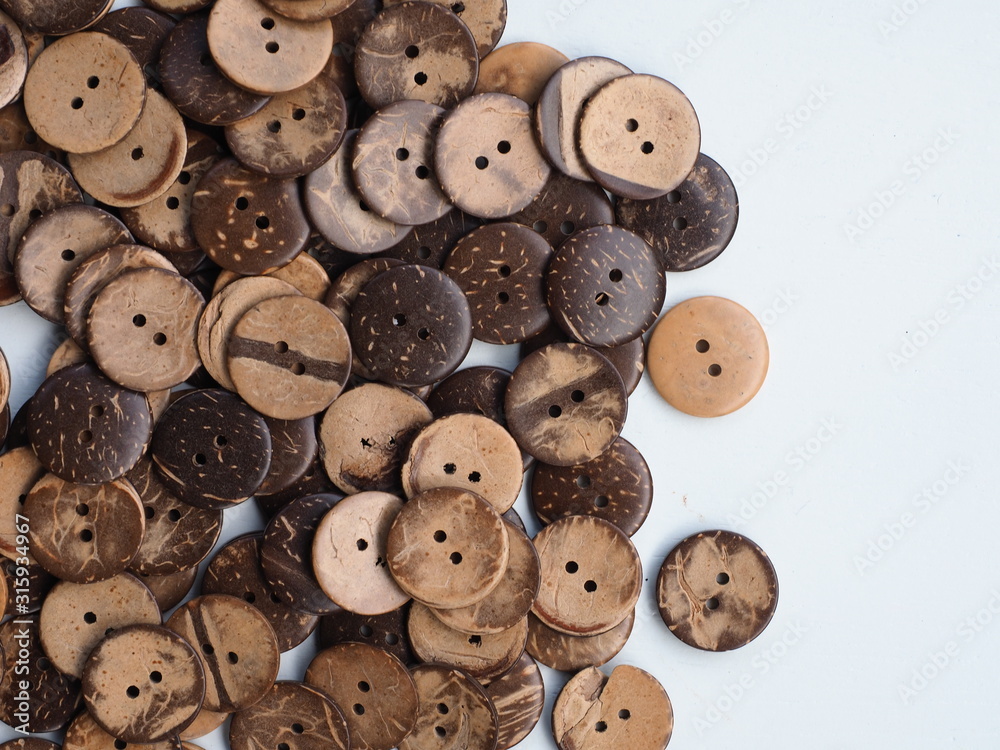 Obraz premium Wooden button on a wooden background, Buttons made from Coconut shell, Top view with copy space.