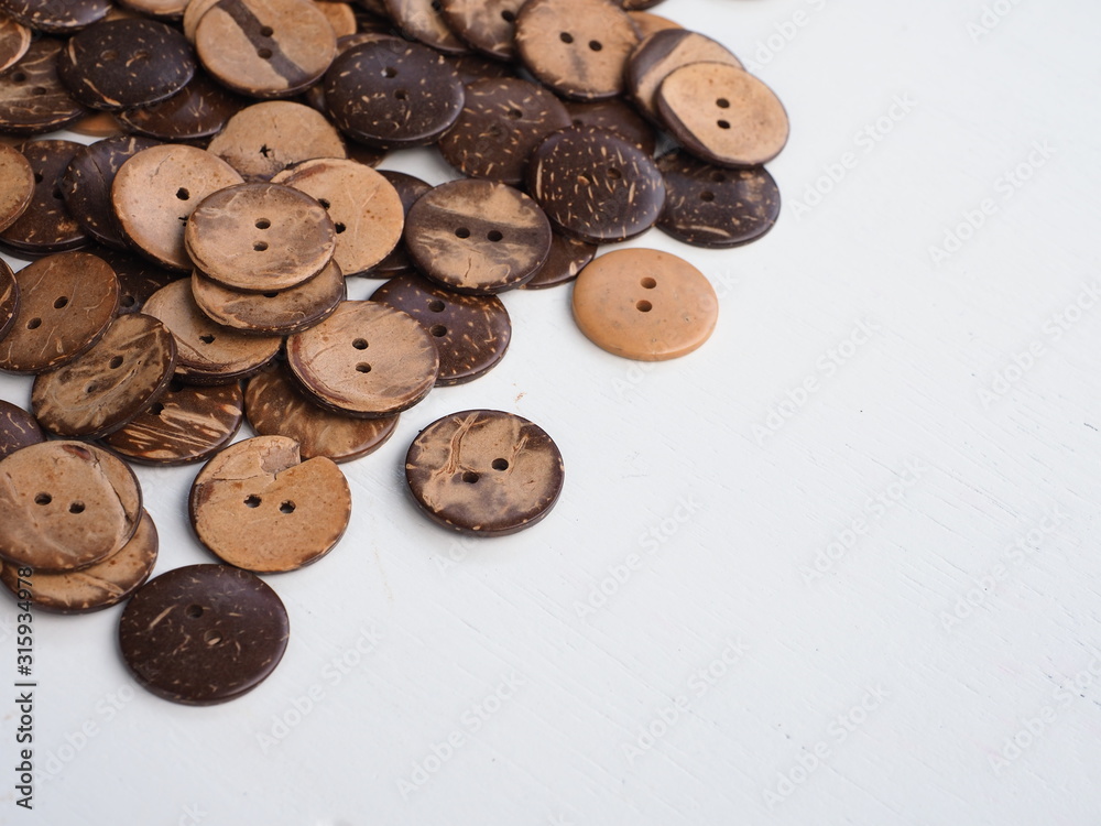 Obraz premium Wooden button on a wooden background, Buttons made from Coconut shell, Top view with copy space.