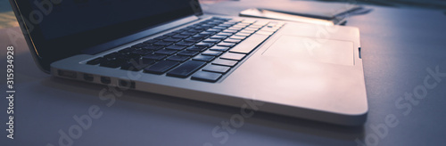 panoramic banner for web, detail view of laptop computer keyboard with sunlight shine on keyboard