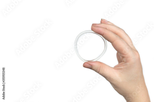 Birth control ring in a womans hand isolated on white background, vaginal ring for contraceptive use
