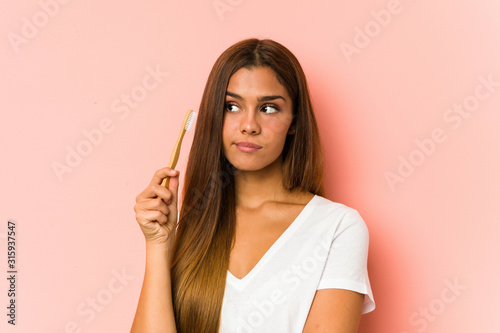 Young caucasian woman cleaning his teeth with a toothbrush isolated