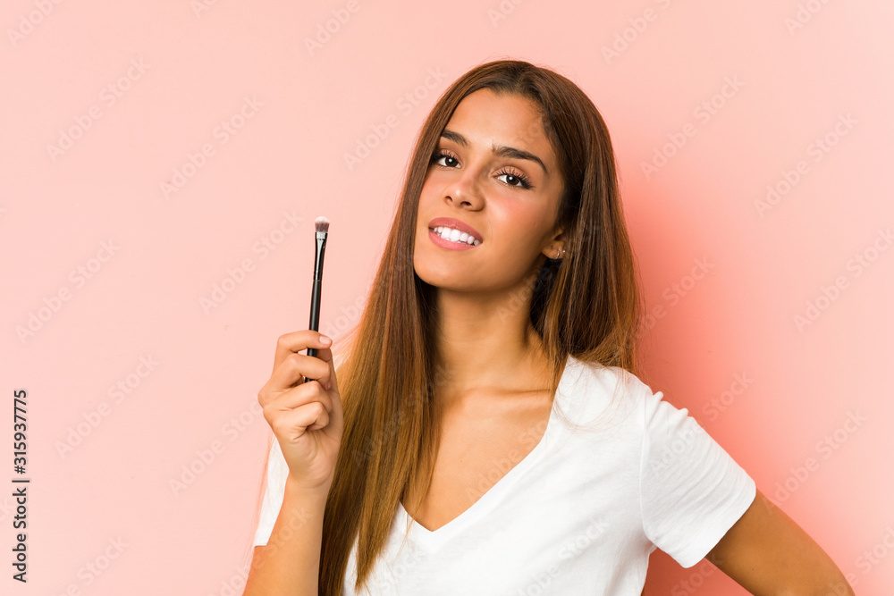 Young caucasian woman holding a eyebrush isolated Young caucasian woman holding a eyebrush isolated