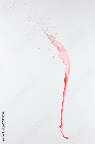 fresh pink milk splash with drops isolated on white