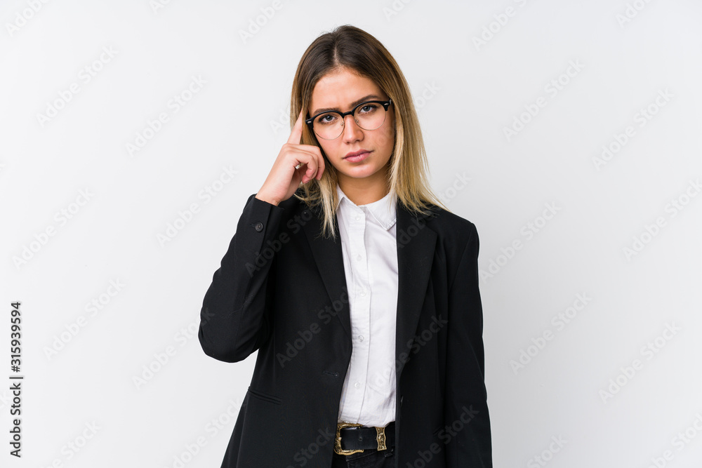 Young business caucasian woman pointing temple with finger, thinking, focused on a task. Young business caucasian woman pointing temple with finger, thinking, focused on a task.