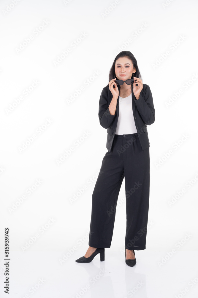 A portrait of a beautiful businesswoman in a black and white officewear and sunglasses isolated on white background. A portrait of a beautiful businesswoman in a black and white officewear and sunglasses isolated on white background.