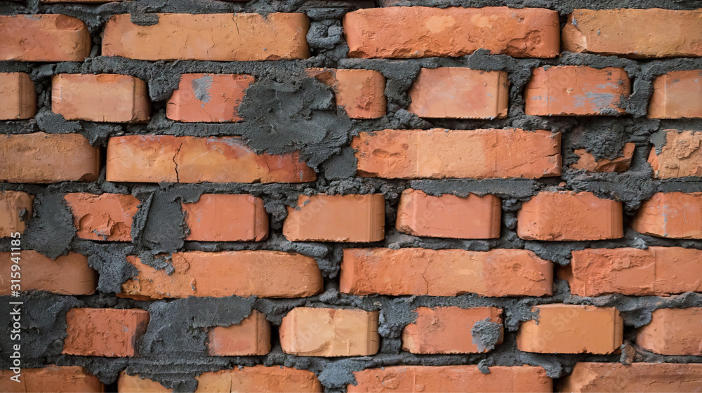 New brown brick wall with gray cement. Close up New brown brick wall with gray cement. Close up