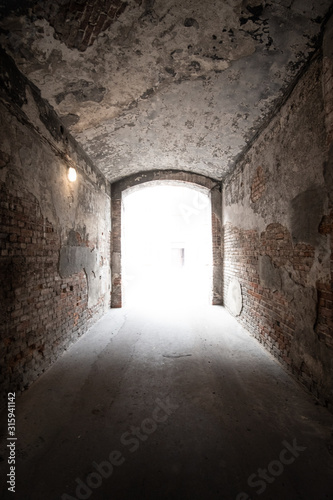 Arch of old abandoned house with light in exit.