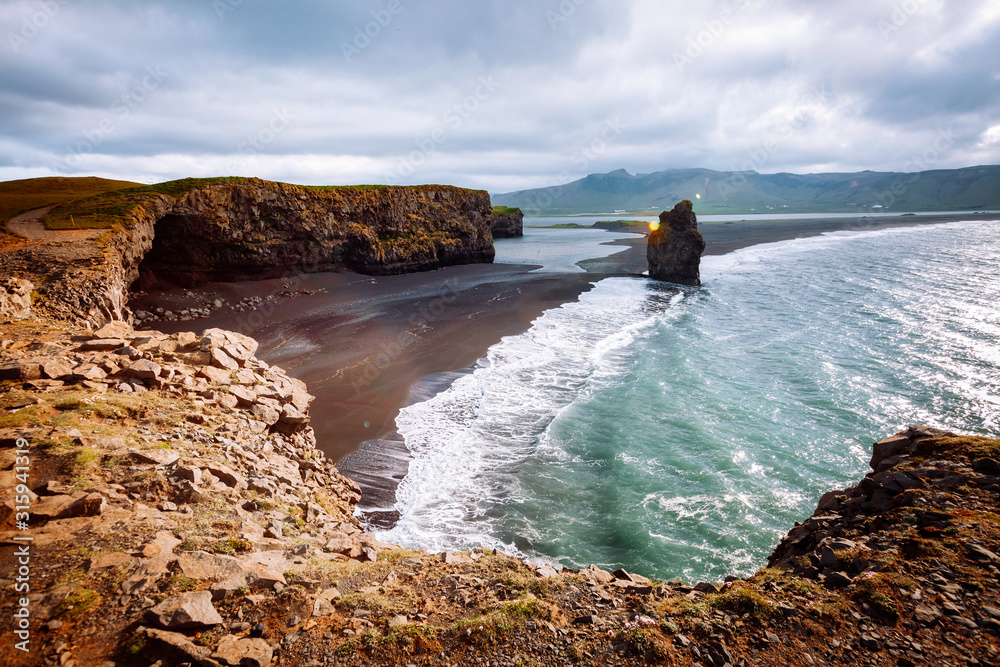 View on Kirkjufjara beach and Arnardrangur cliff. Location Atlantic ocean, Iceland, Europe.