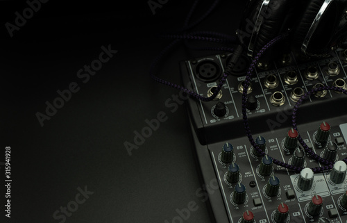Professional sound and audio mixer control panel with buttons and sliders, cables, audio inputs and outputs isolated on a black background, copy-paste, concept music
