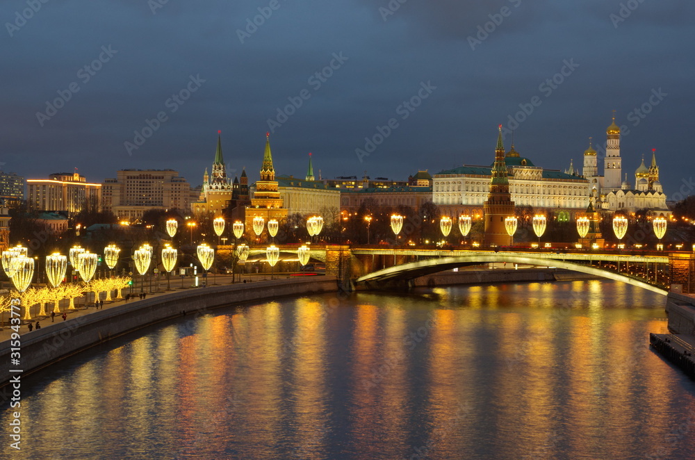 Beautiful evening view of the Moscow Kremlin, the Big Stone bridge and the Prechistenskaya embankment with festive illumination. Moscow, Russia