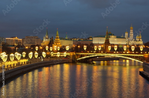 Beautiful evening view of the Moscow Kremlin, the Big Stone bridge and the Prechistenskaya embankment with festive illumination. Moscow, Russia