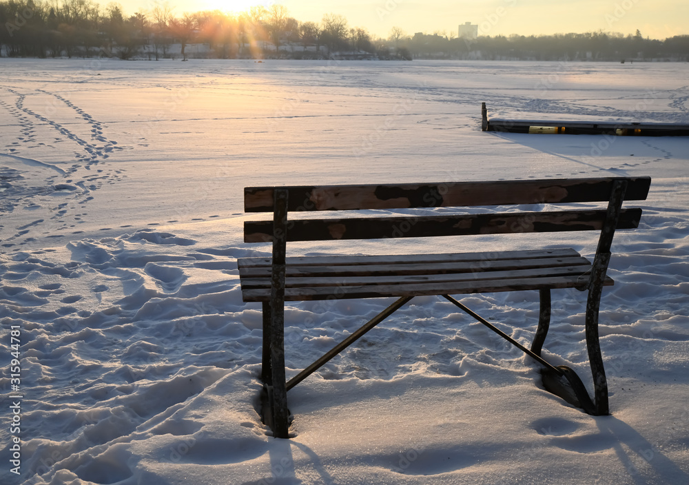 winter park bench along the frozen river