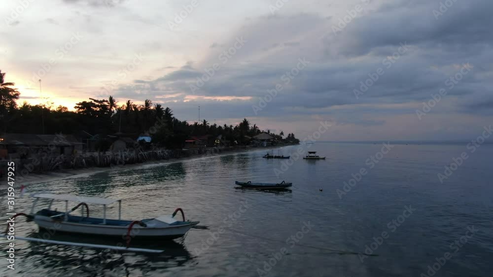 Cinematic 4k aerial video with smooth motion of moored long tail boats at sunset in Crystal bay, Nusa Penida Indonesia Cinematic 4k aerial video with smooth motion of moored long tail boats at sunset in Crystal bay, Nusa Penida Indonesia
