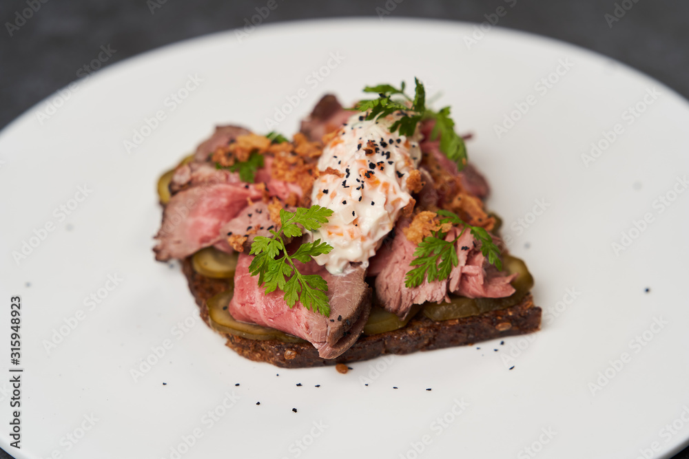 Smorrebrod with roast beef and remoulade sauce on a white plate Smorrebrod with roast beef and remoulade sauce on a white plate