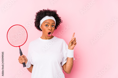 Young african american woman playing badminton isolated pointing to the side © Asier