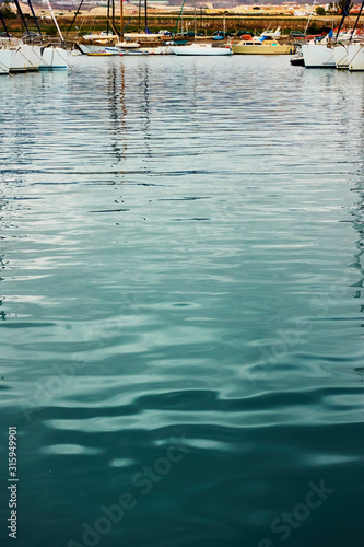 Marina - Water surface with ripple and reflection of yachts