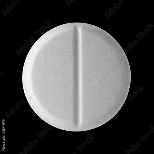 White round pill on a black isolated background. Big pill close up.