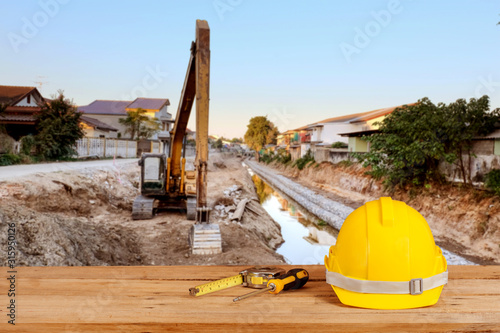 yellow construction safety helmet on wood photo