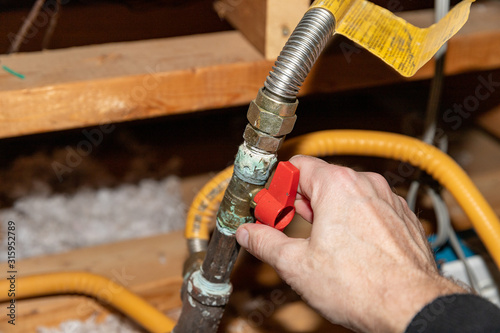 Hand turning safety shut off valve of a natural gas pipe photo