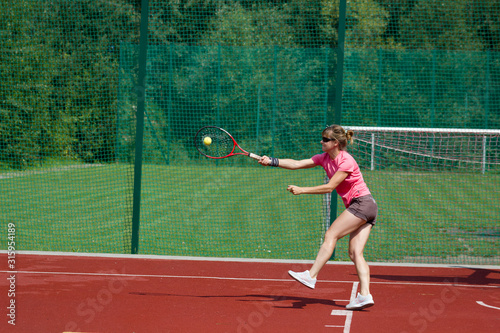 Female tennis player hitting forehand return of serve.