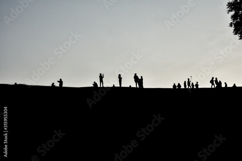 Silhouette of many people standing on the hill