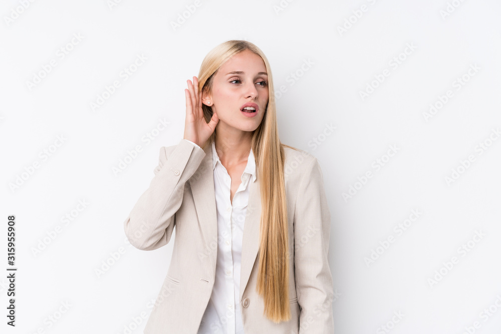 Young business blonde woman on white background trying to listening a gossip.