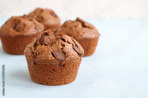chocolate cupcakes with chocolate pieces on a light background.