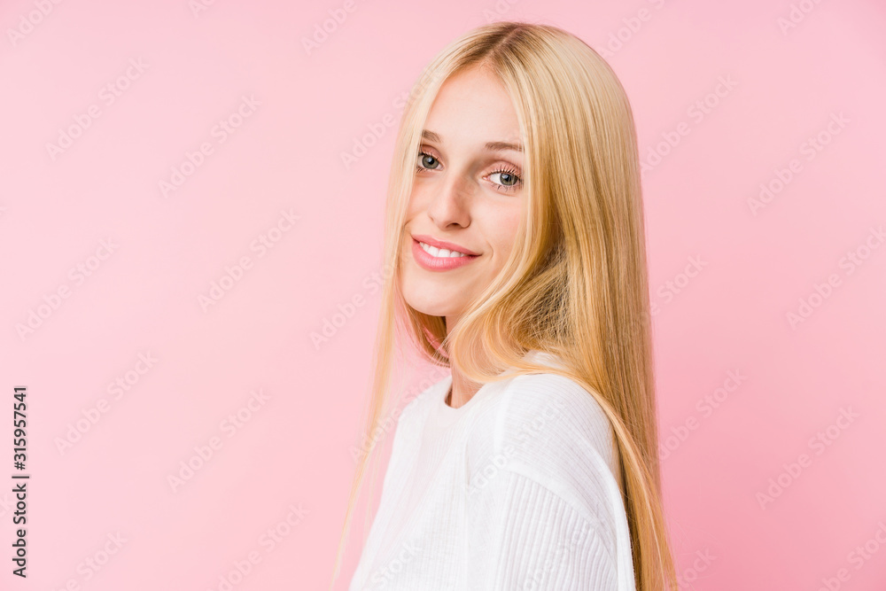 Young blonde woman face closeup isolated on a pink background Young blonde woman face closeup isolated on a pink background