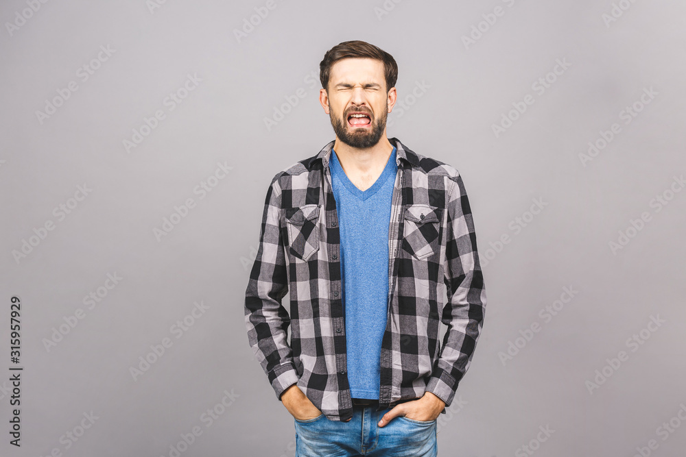 Portrait of sad upset young guy isolated over grey background. Portrait of sad upset young guy isolated over grey background.