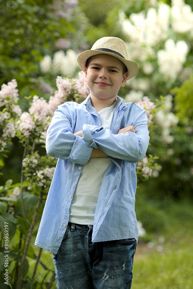 a boy in a hat walks in the spring botanical garden where flowers bloom
