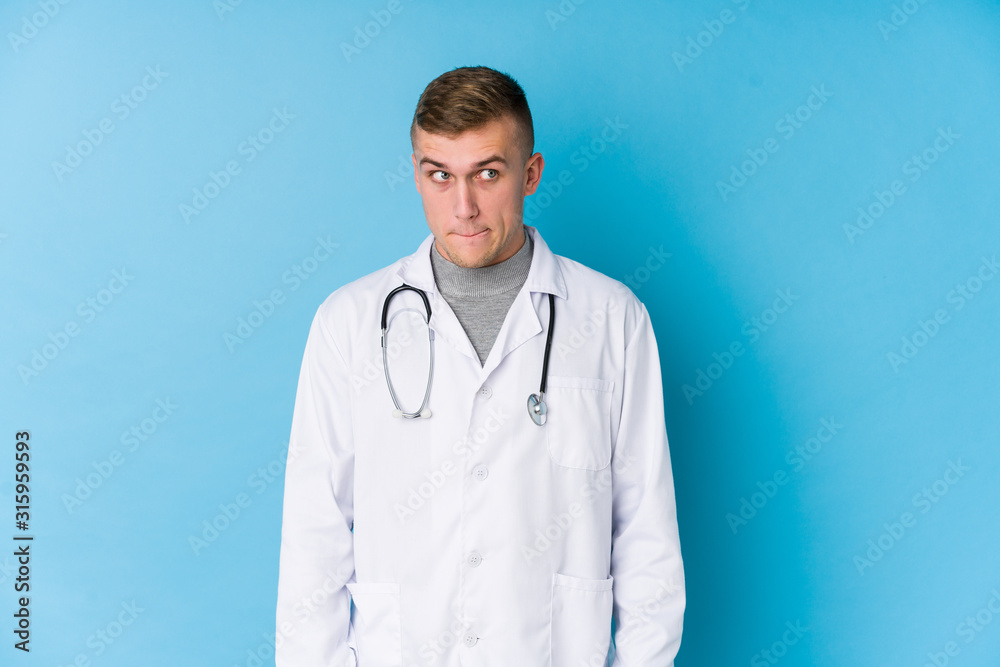 Young caucasian doctor man confused, feels doubtful and unsure. Young caucasian doctor man confused, feels doubtful and unsure.