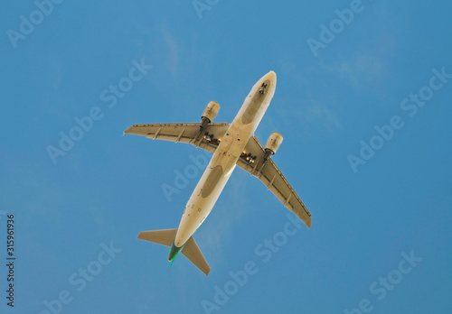 Passenger airplane on a blue sky white clouds background.Leaving flight.Selective soft focus.