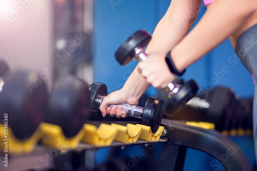 Woman doing workout with dumbbells. People, fitness and health care concept