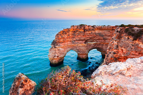 Heart-shaped cliffs on the shore of Atlantic ocean in Algarve, Portugal. Beautiful summer landscape.