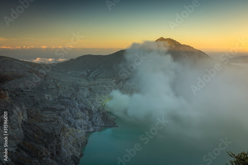 Stunning sunrise or sunset on Ijen Crater. Ijen Crater is a volcanic tourism attraction in Indonesia, located on East Java, famously contains the world’s largest acidic volcanic crater lake.