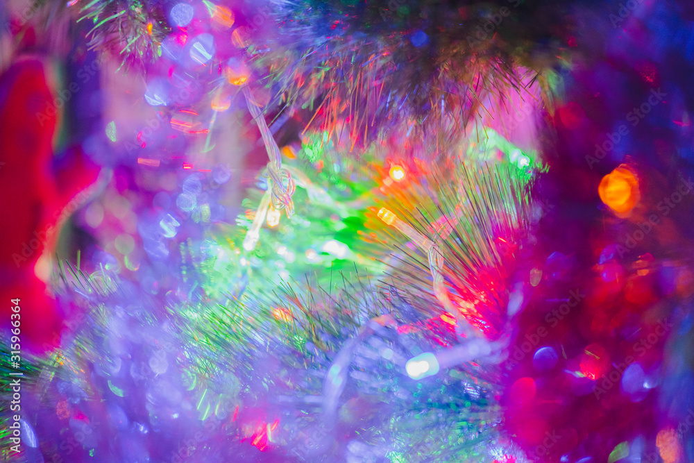 New Year lights in fir tree branches, close-up view. Detailed shot of Christmas tinsel and decorations New Year lights in fir tree branches, close-up view. Detailed shot of Christmas tinsel and decorations