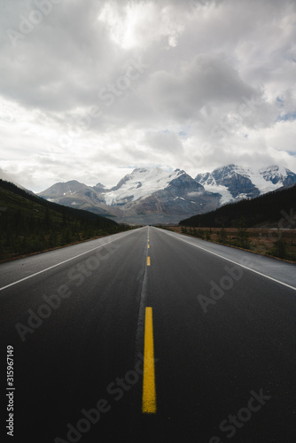 Stunning straight long road leading into Canadian Rocky mountains